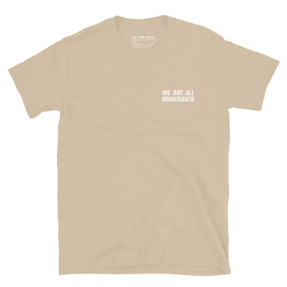 Sand t-shirt with 'We Are All Immigrants' in white text, minimalist design on chest. 