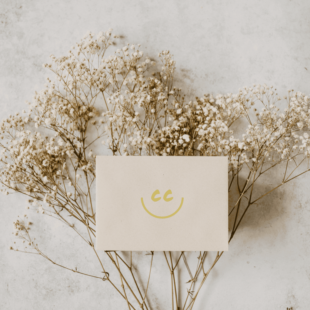 Card with Smile logo resting on a bed of flowers